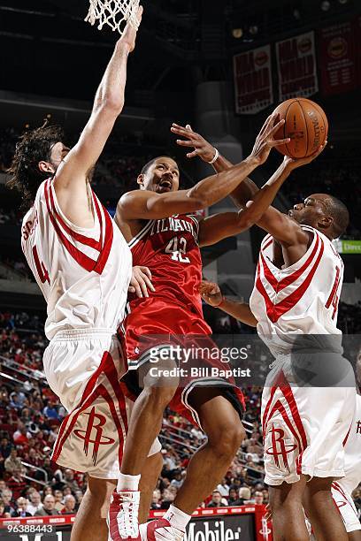 Charlie Bell of the Milwaukee Bucks goes up for a shot against Luis Scola and Carl Landry of the Houston Rockets during the game at Toyota Center on...