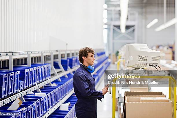 workman at workplace - industrial storage bins stockfoto's en -beelden