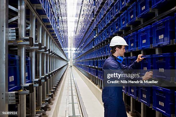 workman in storage - industrial storage bins stockfoto's en -beelden