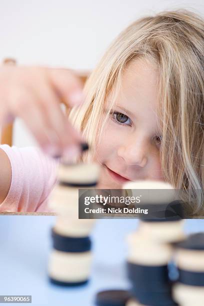 young girl making tower out of dominoes - checkers game ストックフォトと画像