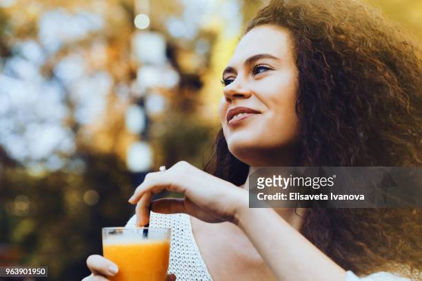 junge frau trinkt orangensaft - elisaveta ivanova stock-fotos und bilder