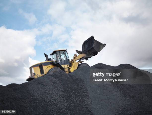 digger on pile of coal in mine - bulldozer photos et images de collection