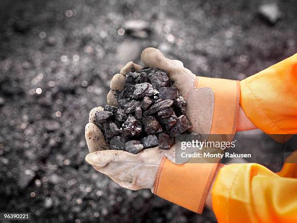 coal worker with handful of coal - mijnindustrie stockfoto's en -beelden