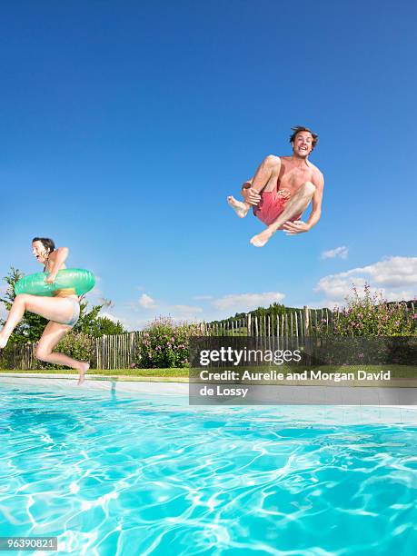 people jumping into pool - jump in pool stock-fotos und bilder