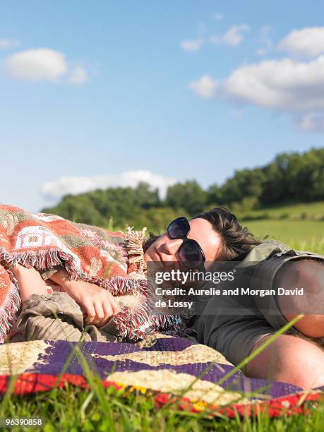 couple lying in field - david de lossy sleep stock pictures, royalty-free photos & images