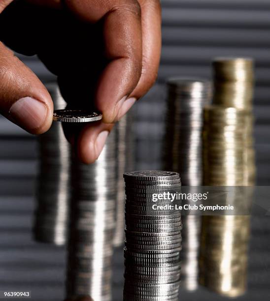 man stacking sterling coins - wealth gap stock pictures, royalty-free photos & images