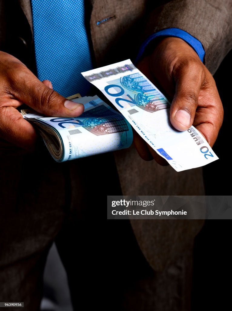 Business man with wad of euro bills