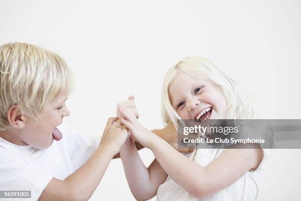 young boy tickling young girl - geschwister frech stock-fotos und bilder