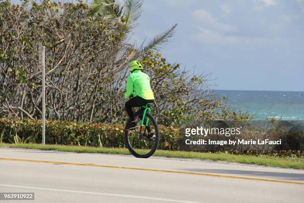 athletic man riding a unicycle near the beach - marie lafauci stock pictures, royalty-free photos & images