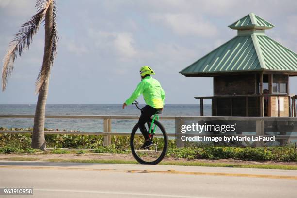 adult man riding a unicycle near the beach - marie lafauci stock pictures, royalty-free photos & images