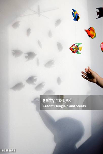 shadow of boy playing with mobile toy - children room stock-fotos und bilder