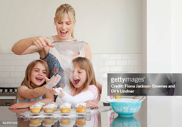 two girls and a mum baking - flour sifter stock pictures, royalty-free photos & images