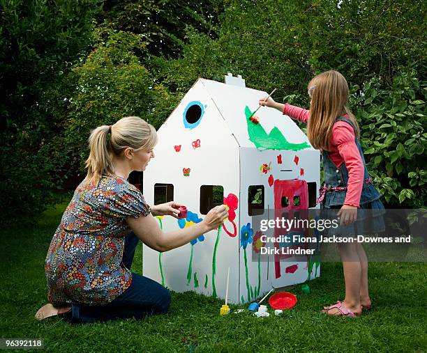 mother and daughter painting together - playhouse stock-fotos und bilder