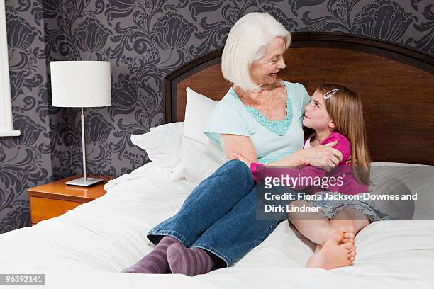 a grandmother and granddaughter hugging - chelsea pensionär stock-fotos und bilder