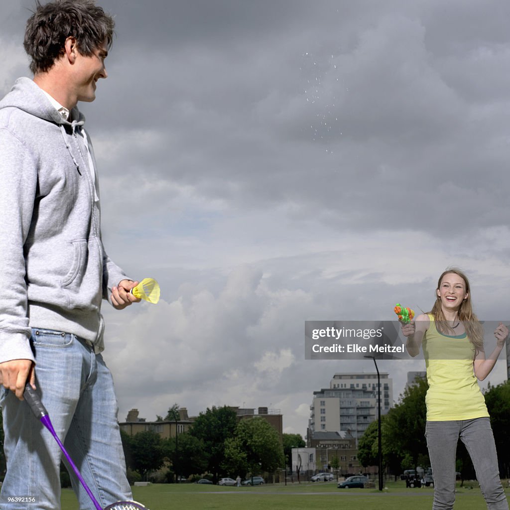 Young couple shooting water pistol