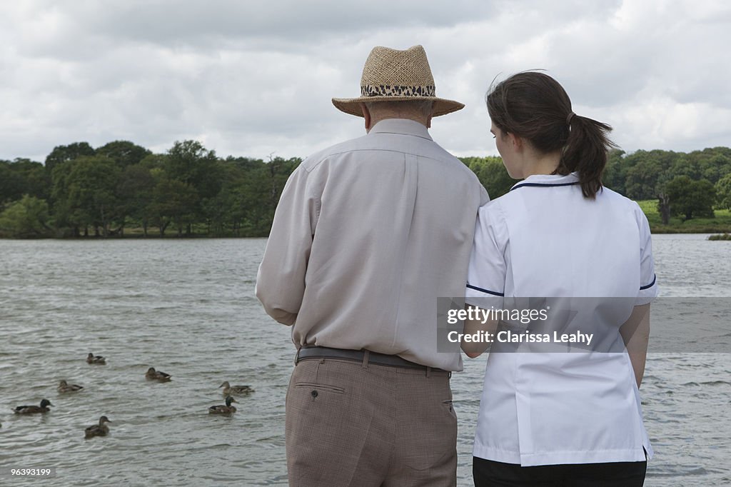 Nurse supporting elderly man