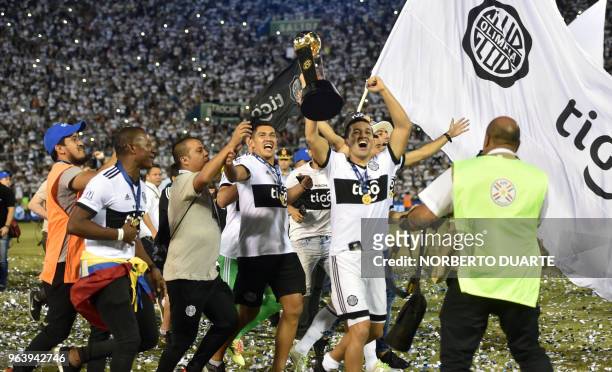 Olimpia's players, celebrate with the trophy after winning the Paraguayan apertura 2018 tournament, at the Defensores del Chaco stadium in Asuncion,...