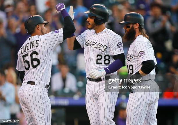 Colorado Rockies outfielder Noel Cuevas and outfielder Charlie Blackmon congratulate infielder Nolan Arenado following a first inning homerun during...