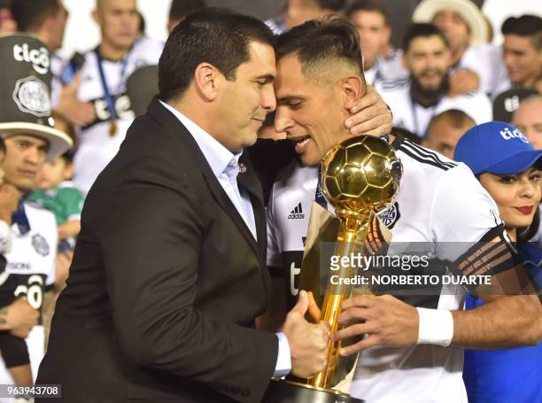Olimpia's captain Roque Santa Cruz receives the trophy from Paraguayan Football Association President Robert Harrison, after winning the Paraguayan...