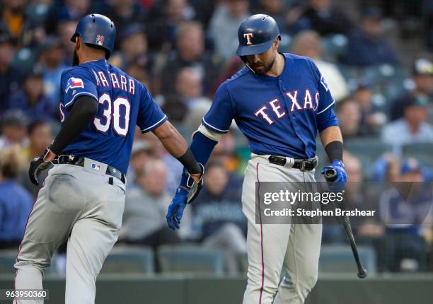 Nomar Mazara of the Texas Rangers is congratulated by Joey Gallo of the Texas Rangers after scoring on a triple by Jurickson Profar of the Texas...