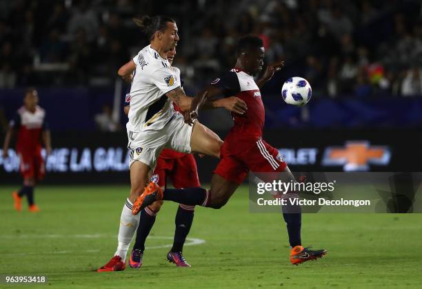 Zlatan Ibrahimovic of Los Angeles Galaxy volleys a pass between Reto Ziegler and Maynor Figueroa of FC Dallas during the first half of their MLS...