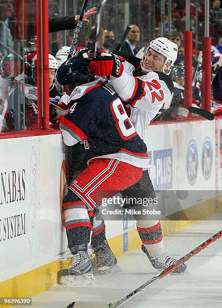 Louis Robitaille of the Lowell Devils and Corey Locke of the Hartford Wolf Pack crash into the boards at the Prudential Center on February 3, 2010 in...