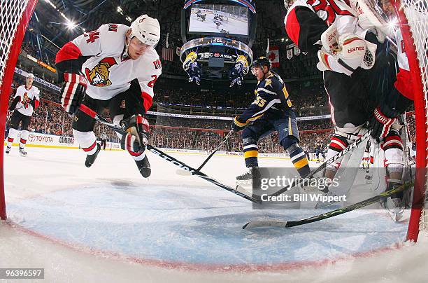 Anton Volchenkov of the Ottawa Senators sweeps the puck away from the goal line behind goaltender Brian Elliott of the Senators as Jochen Hecht of...