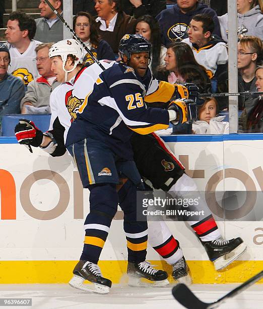 Michael Grier of the Buffalo Sabres checks Matt Carkner of the Ottawa Senators into the boards on February 3, 2010 at HSBC Arena in Buffalo, New York.
