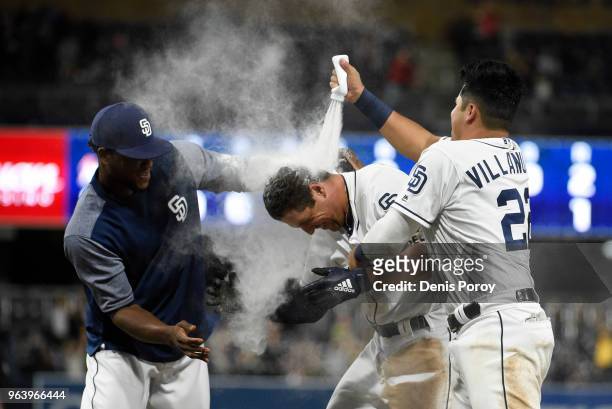 Hunter Renfroe of the San Diego Padres is doused with powder by Franchy Cordero, left, and Christian Villanueva after hitting a game winning single...