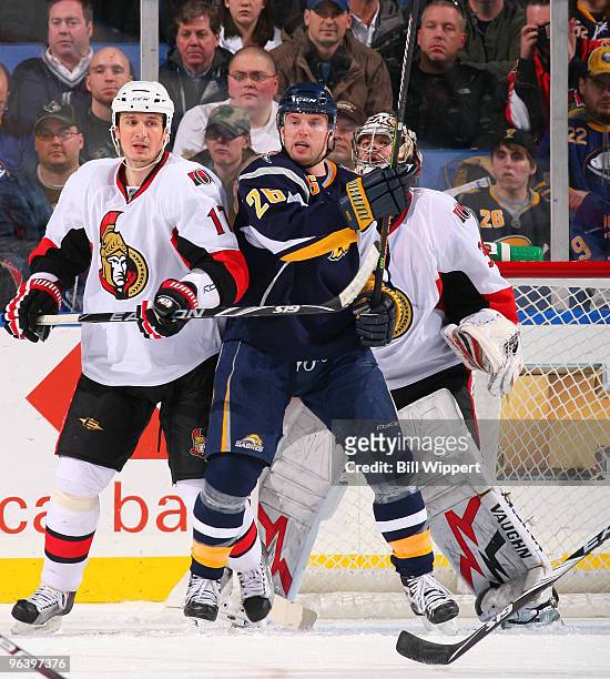 Thomas Vanek of the Buffalo Sabres stands in front of the net between Filip Kuba and Brian Elliott of the Ottawa Senators on February 3, 2010 at HSBC...