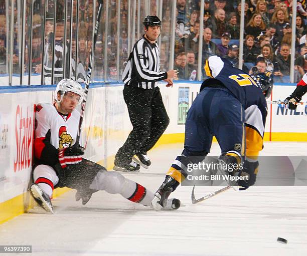 Toni Lydman of the Buffalo Sabres checks Milan Michalek of the Ottawa Senators into the boards on February 3, 2010 at HSBC Arena in Buffalo, New York.