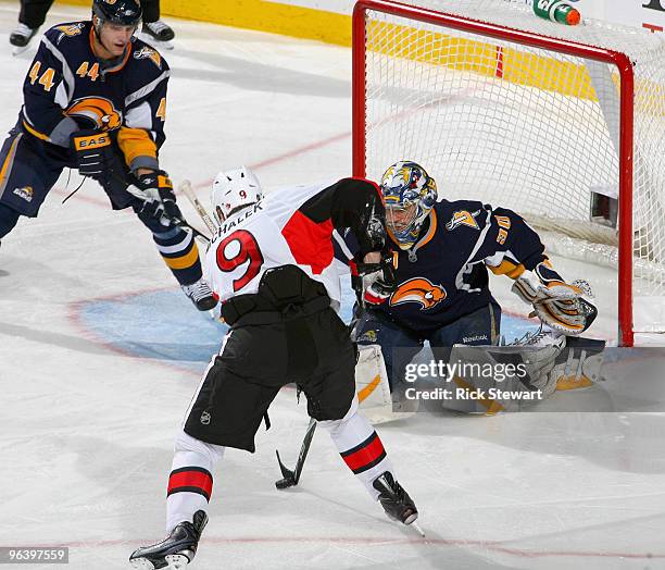 Milan Michalek of the Ottawa Senators dekes Ryan Miller of the Buffalo Sabres but can't get a shot off as Andrej Sekera of the Sabres watches at HSBC...