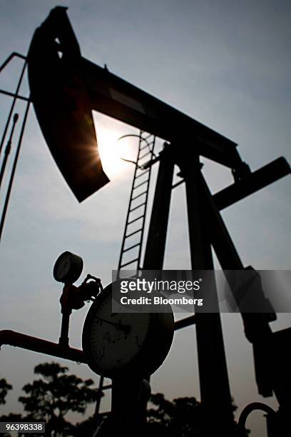 An oil pump in the U-Thong petroleum field is silhouetted against the sun at PTT Exploration & Production Pcl's PTTEP 1 Project site in Amphur Muang,...
