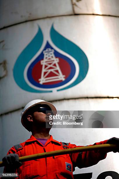 Exploration & Production Pcl production operator Kowan Boonruangjal stands next to the tank where oil is separated from water, right, at PTTEP 1...