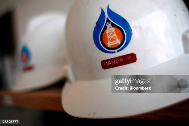The logo of PTT Exploration & Production Pcl is displayed on workers' safety helmets at PTTEP 1 Project site's U-Thong petroleum field, in Amphur...