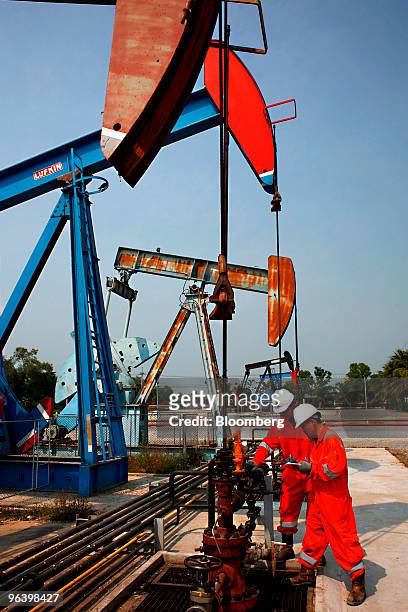 Exploration & Production Pcl production operators Narongrit Wankorn, right, and Kiattikul Roumsuk check the pressure of an oil pump at PTTEP 1...