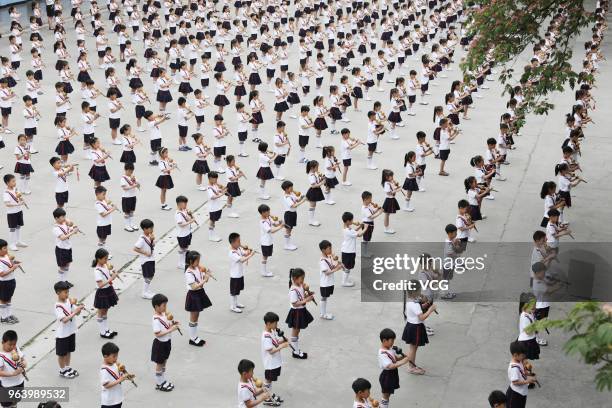 Students of an experimental primary school participate in cucurbit flute performance to welcome upcoming International Children's Day on May 30, 2018...