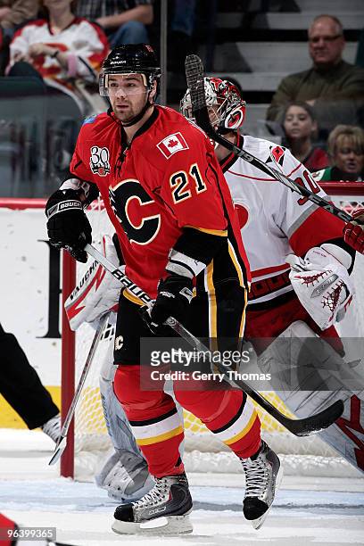 Christopher Higgins of the Calgary Flames skates in front of Cam Ward of the Carolina Hurricanes on February 3, 2010 at Pengrowth Saddledome in...