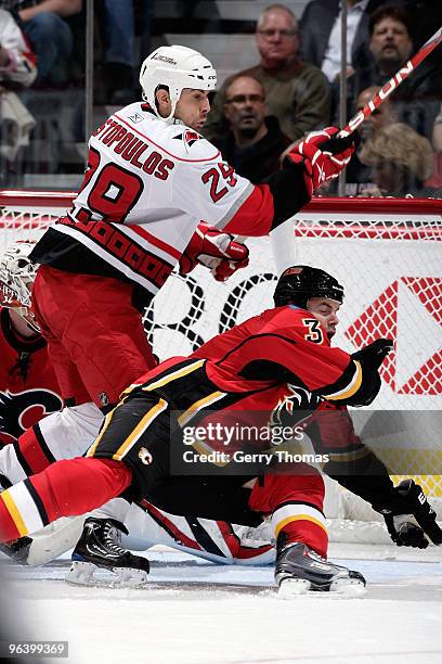 Ian White of the Calgary Flames collides with Tom Kostopoulos of the Carolina Hurricanes on February 3, 2010 at Pengrowth Saddledome in Calgary,...