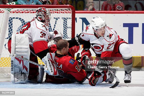 Jarome Iginla of the Calgary Flames is checked into Cam Ward by Brett Carson of the Carolina Hurricanes on February 3, 2010 at Pengrowth Saddledome...