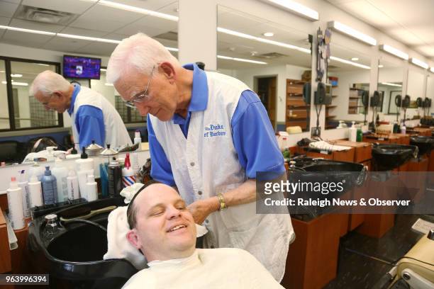 David Fowler, the main barber at Duke Barbershop, washes longtime customer Adam Connor's hair on May 25, 2018. Fowler has cut hair there for over 50...