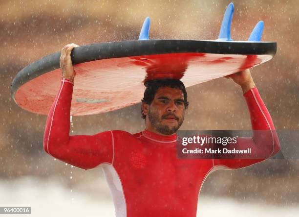 Greg Inglis of the Storm carries his surfboard during a Melbourne Storm NRL training session at Anglesea Beach on February 4, 2010 in Anglesea,...