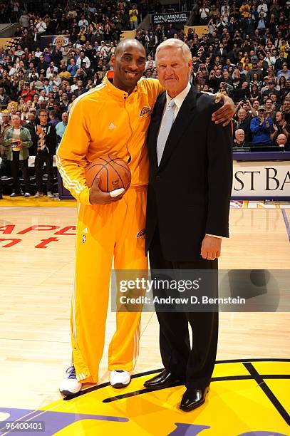 Kobe Bryant of the Los Angeles Lakers is presented with the game ball by former Laker Jerry West before a game against the Charlotte Bobcats at...