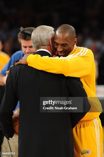 Kobe Bryant of the Los Angeles Lakers is presented with the game ball by former Laker Jerry West before a game against the Charlotte Bobcats at...