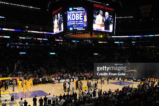 Kobe Bryant of the Los Angeles Lakers is presented with the game ball by former Laker Jerry West before a game against the Charlotte Bobcats at...