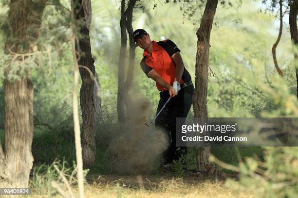 Peter Hanson of Sweden plays his second shot at the par 5, 13th hole during the first round of the 2010 Omega Dubai Desert Classic on the Majilis...