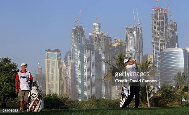 Paul Lawrie of Scotland plays his second shot at the par 5, 13th hole during the first round of the 2010 Omega Dubai Desert Classic on the Majilis...