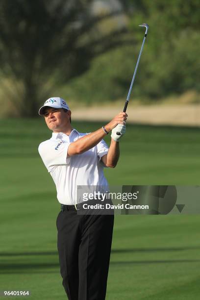 Paul Lawrie of Scotland plays his third shot at the par 5, 13th hole during the first round of the 2010 Omega Dubai Desert Classic on the Majilis...