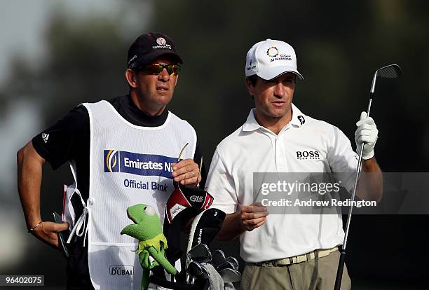 Steve Webster of England waits with his caddie on the third hole during the first round of the Omega Dubai Desert Classic on February 4, 2010 in...