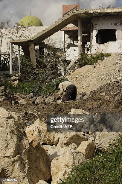 Lebanese villager Hussein Srur works on February 1, 2010 on reparing the insfrastructure installations near the rubble of a house which was destroyed...